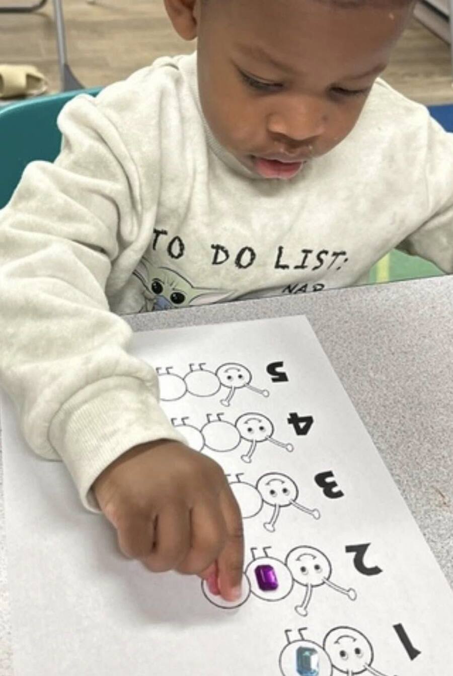 A child counting with jewel stickers